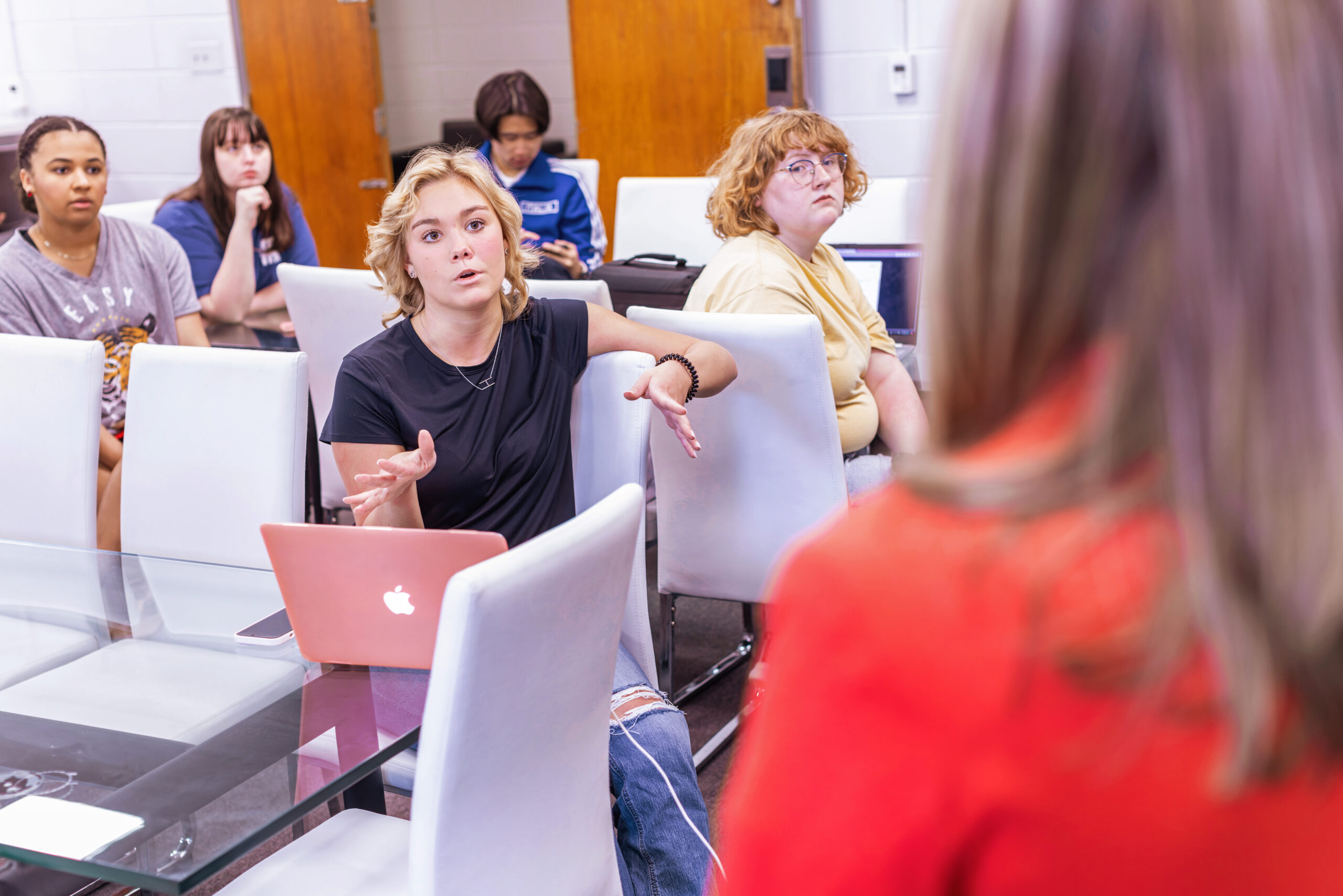 Student with laptop asking her instructor a question