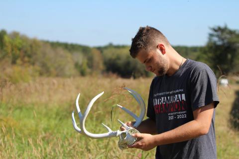 UWA student with antlers in field