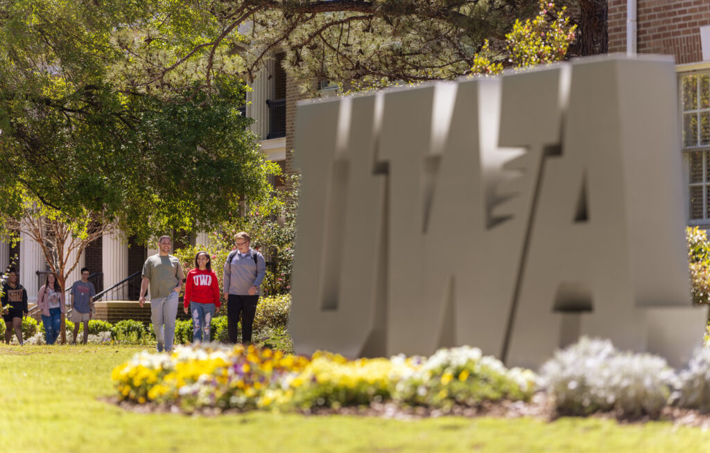 students walking by UWA letters