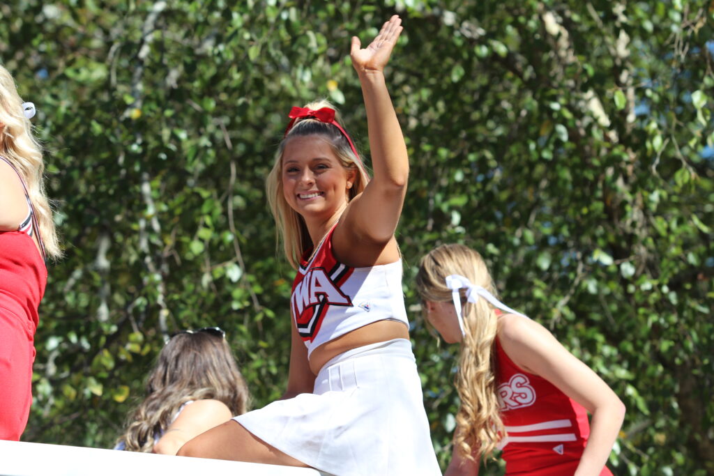 UWA Cheerleader waving to parade watchers